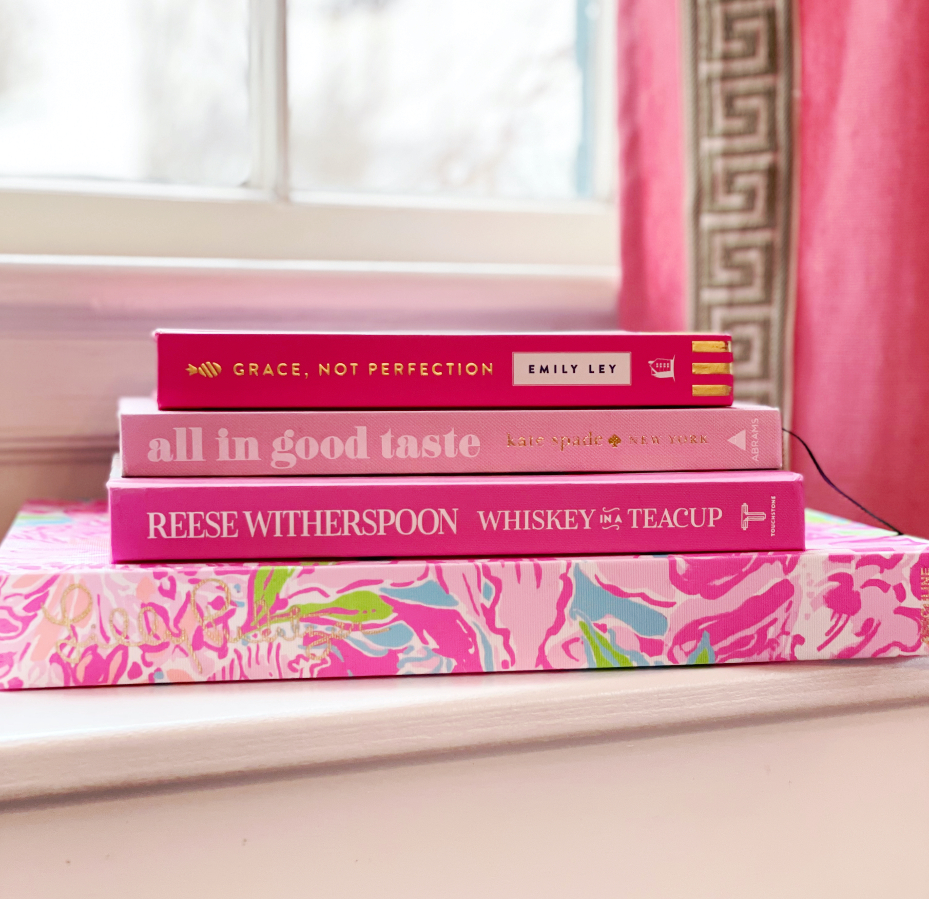 A stack of Pink Coffee Table books on a white surface